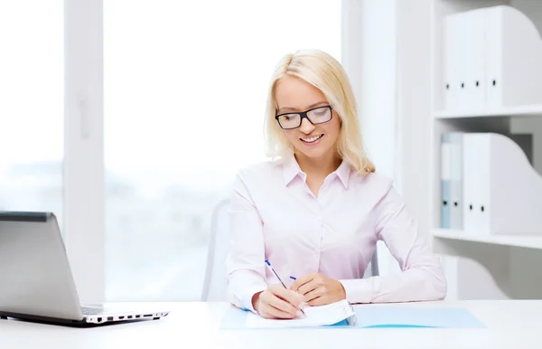 Sonriente mujer de negocios leyendo papeles en la oficina —  Fotos de Stock