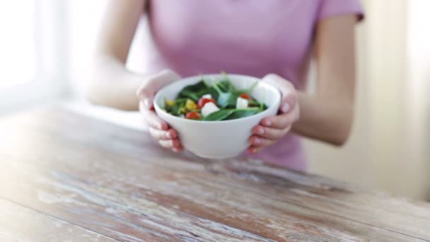 Close up de mãos de mulher jovem mostrando tigela de salada — Vídeo de Stock