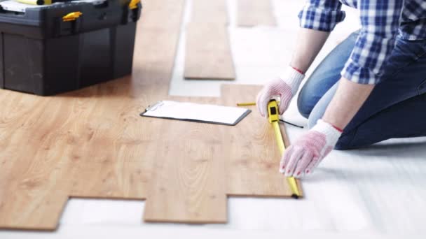 Крупним планом чоловік вимірює підлогу і пише — стокове відео