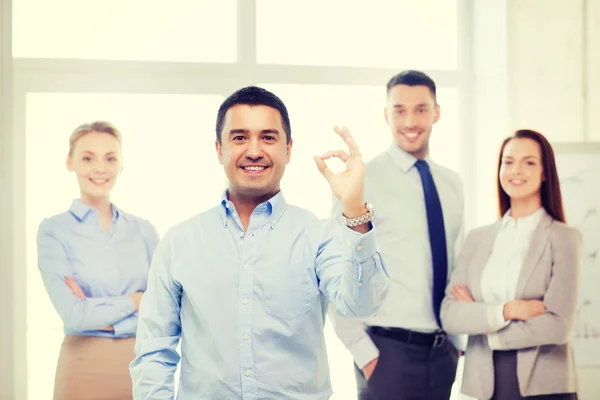 Empresário sorridente mostrando ok-sign no escritório — Fotografia de Stock