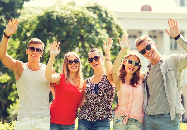 Grupo de amigos sonrientes agitando las manos al aire libre — Foto de Stock