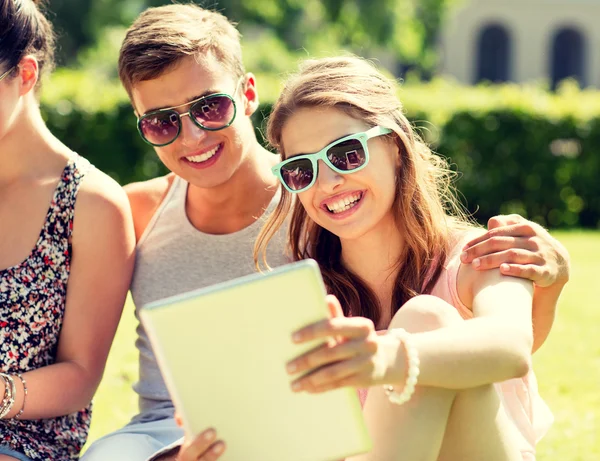 Amigos sonrientes con Tablet PC en el parque — Foto de Stock