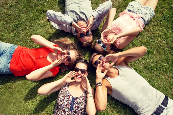 야외 잔디에 누워 웃는 친구의 그룹 — 스톡 사진