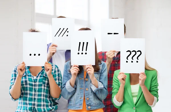 Friends or students covering faces with papers — Stock Photo, Image