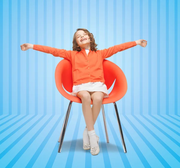 Gelukkig meisje, zittend op ontwerper stoel — Stockfoto