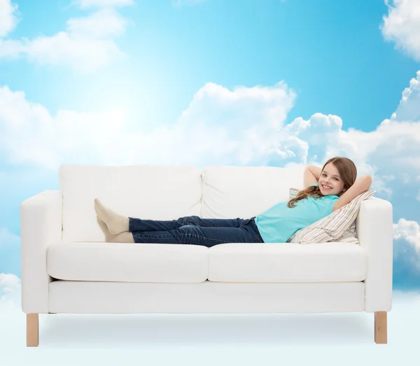 Smiling little girl lying on sofa — Stock Photo, Image