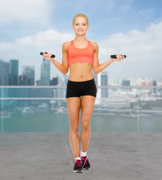 Sonriente deportista mujer saltando con saltar la cuerda — Foto de Stock