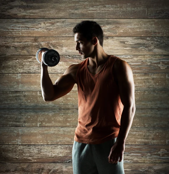 Młody człowiek z wyginanie biceps hantle — Zdjęcie stockowe