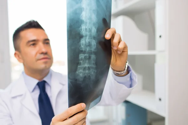 Крупным планом врача в белом халате, смотрящего на рентген — стоковое фото