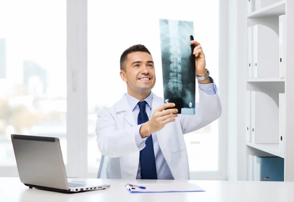 Sorridente médico masculino em casaco branco olhando para raio-x — Fotografia de Stock