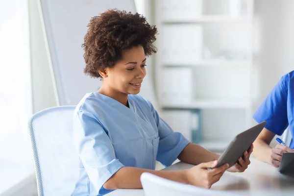 Mujer feliz médico o enfermera con tableta pc — Foto de Stock