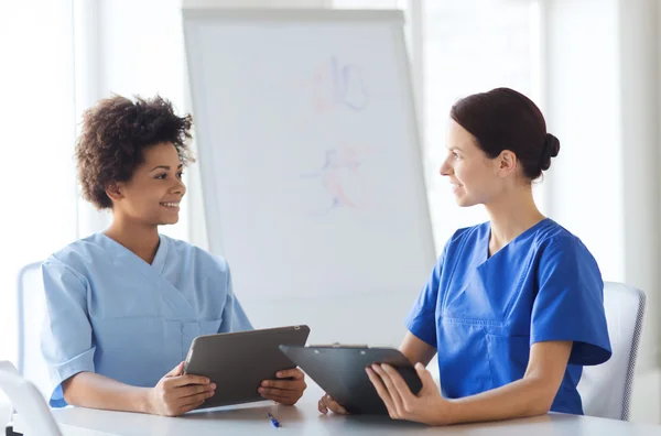 Medici felici con tablet pc riunione in ospedale — Foto Stock