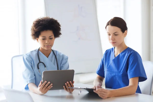 Médicos com tablet pc reunião no hospital — Fotografia de Stock