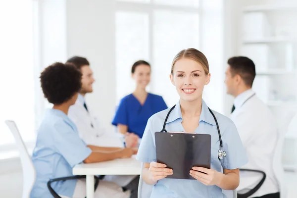 Zufriedener Arzt über Gruppe von Sanitätern im Krankenhaus — Stockfoto