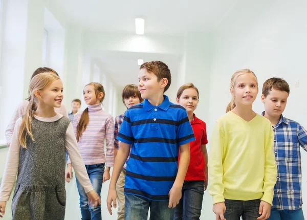 Groupe d'écoliers souriants marchant dans le couloir — Photo