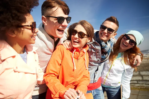 Amis souriants dans des lunettes de soleil riant dans la rue — Photo