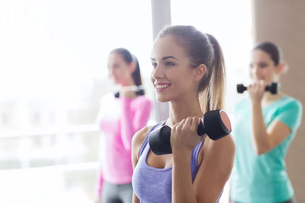 Groep gelukkig vrouwen met halters in gym — Stockfoto
