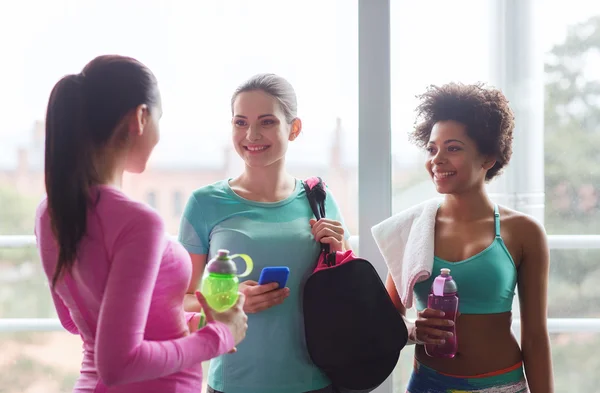 Gelukkig vrouwen met flessen water in de sportschool — Stockfoto