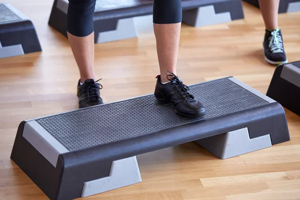 Close up van vrouwen uitoefenend met stepper in gym Rechtenvrije Stockfoto's