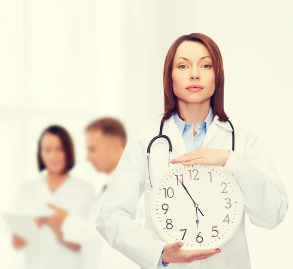 Klidná ženského lékaře s nástěnné hodiny — Stock fotografie