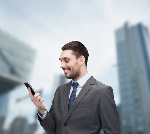 Jeune homme d'affaires souriant avec smartphone — Photo