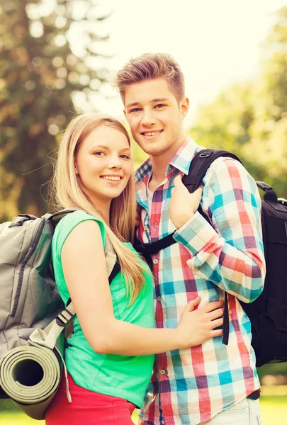 Sorrindo casal com mochilas na natureza — Fotografia de Stock