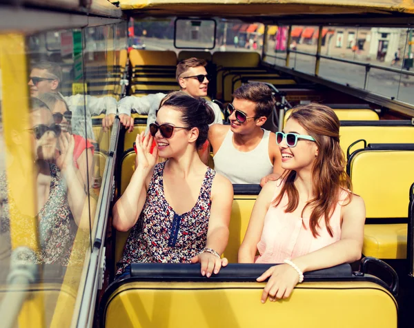 Gruppo di amici sorridenti che viaggiano in autobus turistico — Foto Stock