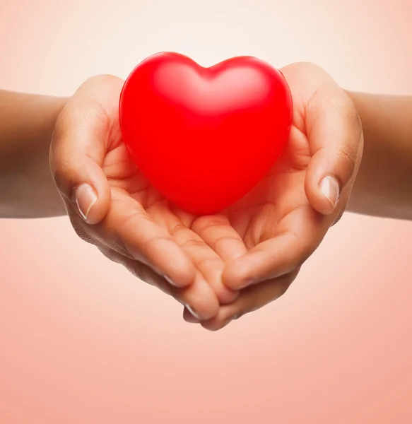 Close up of female hands holding small red heart — Stock Photo, Image