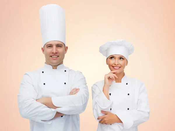 Felizes chefs ou cozinheiros casal sobre fundo bege — Fotografia de Stock