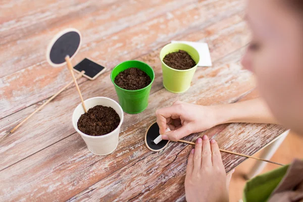 Close up of woman writing name on garden sign — Stock Photo, Image