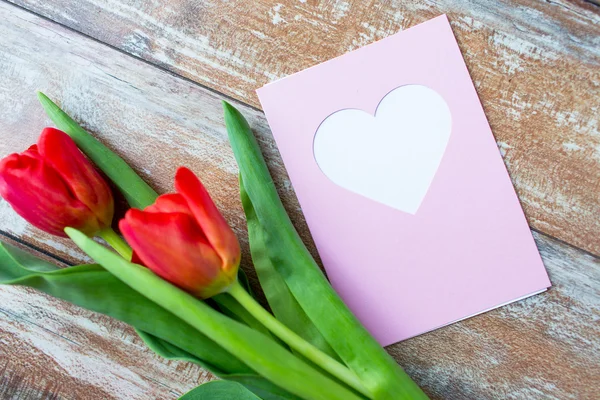 Close up de tulipas e cartão de saudação com coração — Fotografia de Stock