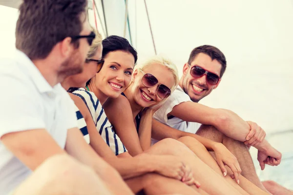 Amigos sonrientes sentados en la cubierta del yate —  Fotos de Stock