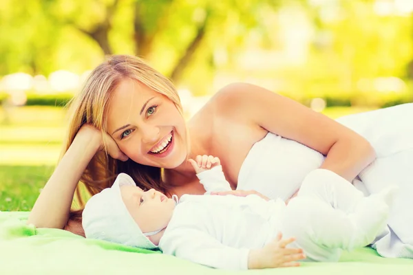 Rire mère couché avec petit bébé sur couverture — Photo