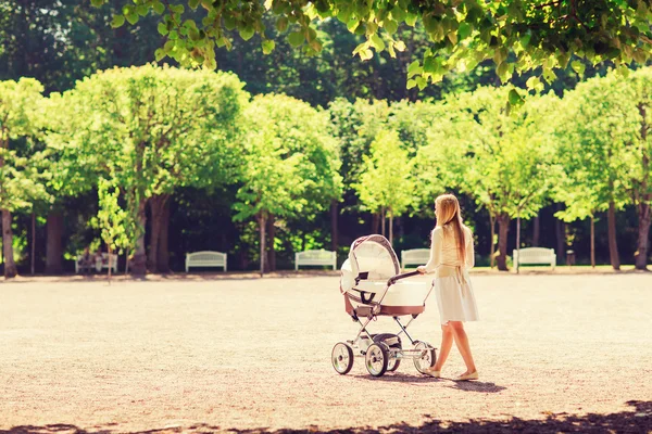 Happy mother with stroller in park — Stock Photo, Image