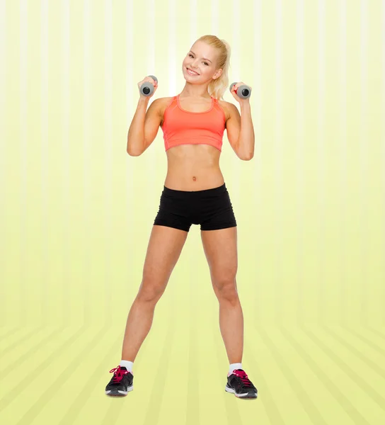 Young sporty woman with dumbbells — Stok fotoğraf