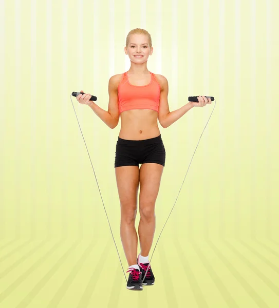 Sonriente deportista mujer saltando con saltar la cuerda — Foto de Stock