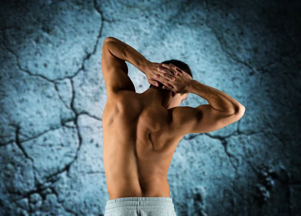 Young man or bodybuilder showing muscles — Stock Photo, Image