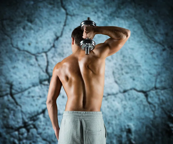 Young man with dumbbell flexing biceps — Stock Photo, Image