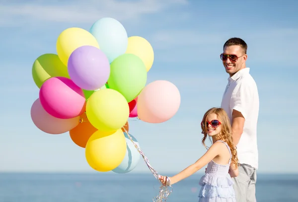 Glücklicher Vater und Tochter mit bunten Luftballons — Stockfoto