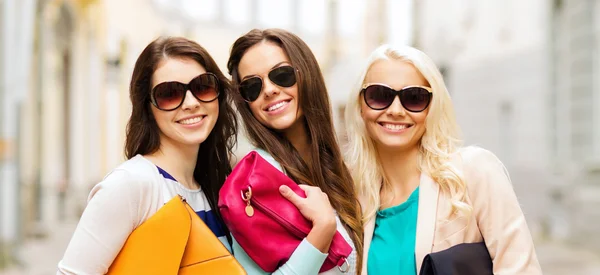 Три усміхнені жінки з сумками в місті — стокове фото