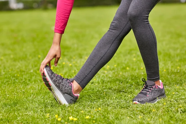 Primer plano de la mujer que estira la pierna al aire libre —  Fotos de Stock