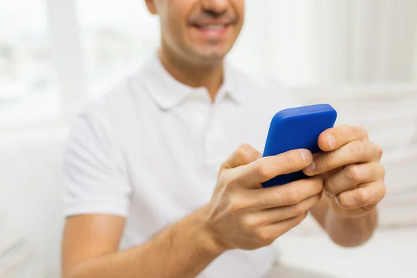 Primer plano del hombre feliz con teléfono inteligente en casa — Foto de Stock