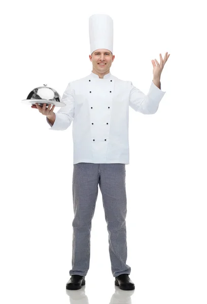 Feliz chef masculino cozinhar segurando cloche — Fotografia de Stock