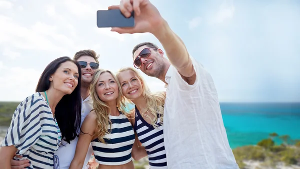 Friends on beach taking selfie with smartphone Stock Picture