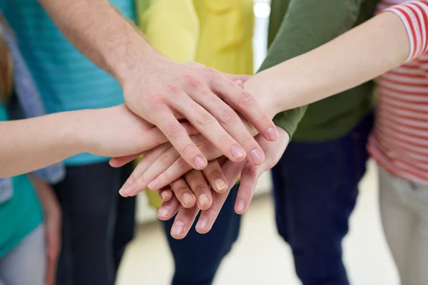Close up of students or friends with hands on top — Stock Photo, Image