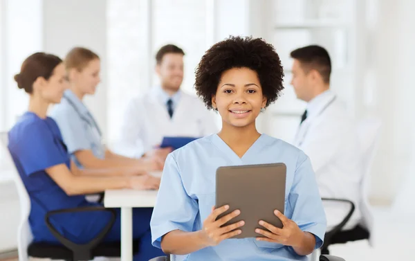 Glada läkare med TabletPC över laget på klinik — Stockfoto