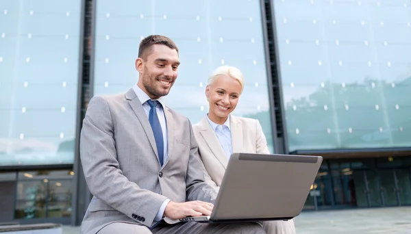 Uomini d'affari sorridenti con computer portatile all'aperto — Foto Stock