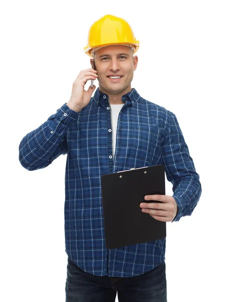 Lachende bouwer in helm opgeroepen smartphone — Stockfoto