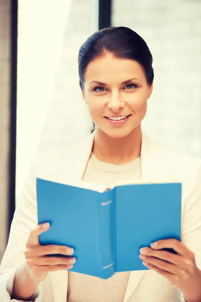 Mulher feliz e sorridente com livro — Fotografia de Stock