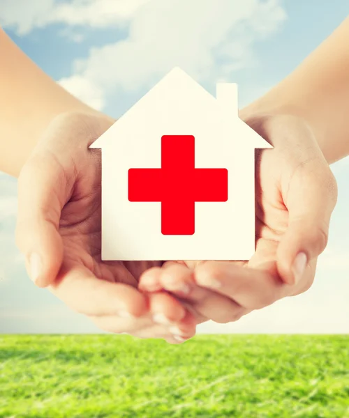 Hands holding paper house with red cross — Stock Photo, Image